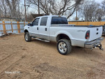 2000 Ford F250 Super Duty V10 4x4 truck with upgraded axel and new tires parked on gravel