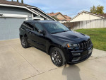 2020 Jeep Grand Cherokee Limited X, black SUV, parked in front of a house, showing elegant design and exterior features.