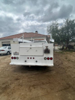 Rear view of a 2001 Chevrolet Silverado 3500 with a white service body parked in a yard