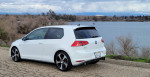 2015 Volkswagen GTI parked by a lake, showcasing its clean design and sporty features.