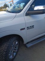 Close-up of 2014 Ram 1500 truck with HEMI badge and chrome rims, showcasing its sleek design and features.