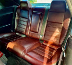 Interior view of the back seats in a 2014 Dodge Challenger SXT, showcasing brown leather upholstery.
