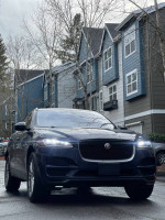 Luxury Jaguar F-PACE SUV parked with modern buildings in the background, showcasing its sleek design.