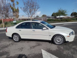2004 Volvo S80 2.9 with 104,000 miles, featuring sleek design, white exterior, and alloy wheels parked on the street.