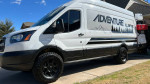 Custom 2017 Ford Transit 250 adventure motovan with off-road tires and upgraded features.