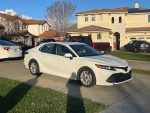 2021 Toyota Avalon parked in front of a house, showcasing its pristine white exterior and new condition.