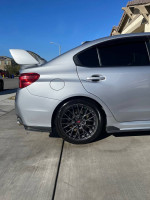 Side view of a 2016 Subaru WRX STI with black wheels parked on a driveway