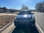 Front view of a blue 2011 Subaru Outback parked on the street, ready for sale.