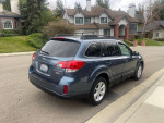 2013 Subaru Outback 2.5i AWD parked on street, showcasing its clean design and manual transmission features.