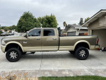 2014 Ram 3500 Longhorn with custom suspension and wheels, parked in driveway.