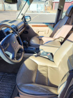 Interior view of a 1999 Land Rover Discovery showing the seats, steering wheel, and dashboard.