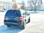 2010 Ford Escape parked with clear view, showcasing its clean exterior and powerful stance.