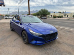 2021 Hyundai Elantra in blue color parked by the roadside with alloy wheels and a scenic backdrop.