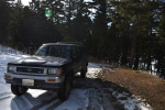 1993 Toyota Pickup with 104,000 miles, parked on snowy terrain surrounded by trees, showing great condition.