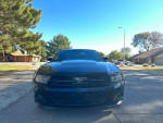 Front view of a 2012 Ford Mustang V6 in black, showcasing its sleek design and luxury features.