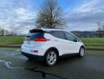 2019 Chevrolet Bolt EV parked on a road, showcasing its compact design and modern features.