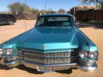 Front view of a 1963 Cadillac Fleetwood in turquoise, showcasing its vintage luxury and classic design.