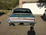 Rear view of a 1971 Ford Thunderbird in good condition with green exterior and black vinyl top.