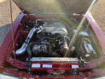 1987 Ford Mustang 5.0 engine with cold air intake and new battery, ready for performance.