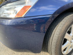 Close-up of a 2005 Honda EX-L V6 showing front tire and headlight, highlighting well-maintained exterior.