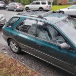 1997 Subaru Impreza Outback Sport in green color parked on the street, showcasing its sleek design and good condition.