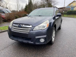 2013 Subaru Outback wagon with all-wheel drive, heated seats, and leather interior parked on a rainy street