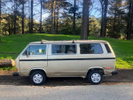1987 Volkswagen Vanagon parked in nature, showcasing its original design and rustic charm.