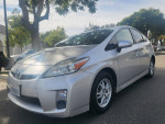 2010 Toyota Prius touring model in silver with low mileage, parked under trees, showcasing its clean exterior.