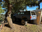 2007 Toyota 4Runner parked near a tree, featuring off-road tires and custom suspension.