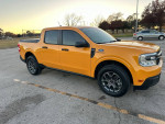 2023 Ford Maverick XLT in Cyber Metallic Orange, parked in a grassy area, showcasing clean condition and new features.