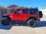 2012 Jeep Wrangler Unlimited Rubicon with custom lift and accessories, parked in residential area