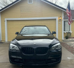 Front view of a 2013 BMW 750Li xDrive M Sport in black with garage and house in the background.