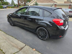2016 Subaru Impreza hatchback in black with low mileage, showcasing stylish wheels and modern features.