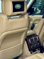 Interior view of a 2014 Land Rover Range Rover with tan leather and Land Rover logo on headrest