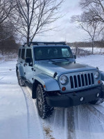 2012 Jeep Wrangler Unlimited Arctic Edition in snow, showcasing four-wheel drive and removable hard-top features.