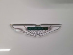 Aston Martin logo on a pristine 2015 V8 Vantage GT in white, showcasing luxury and engineering excellence.