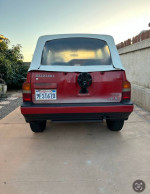 Rear view of a 1989 Suzuki Sidekick JLX, featuring a white soft top, parked outdoors.