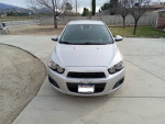 Front view of a silver 2012 Chevrolet Sonic LT with low mileage parked on a driveway.