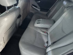 Interior view of a 2010 Toyota Prius with leather seats and cup holders, well-maintained but sold as-is.