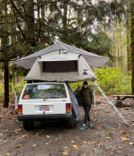 1993 Jeep Cherokee Country with rooftop tent in a forest campsite, ideal for adventures and camping.