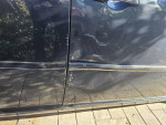 Close-up of a damaged door on a steel blue Chrysler 300 Touring Sedan with a scratched area.