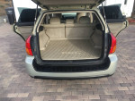 2007 Subaru Outback trunk space with carpeted floor and rear seats folded for storage.