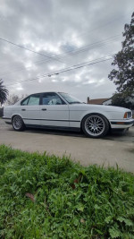 1989 BMW e34 535i in white with BBS wheels parked outdoors, showcasing its clean exterior and classic style.