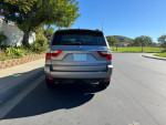 Rear view of a 2007 BMW X3 3.0si AWD SUV parked in a sunny residential area.