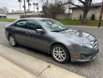 2010 Ford Fusion in gray with new tires, comfortable seating, and stylish interior lighting, parked on the street.