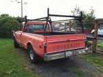 1968 Chevrolet C10 pickup truck with a long bed parked in a yard, showcasing its rear view.