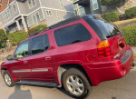 2002 GMC Envoy in red with clean title, great condition and family-friendly 7-seat capacity for sale.