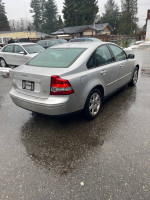 2006 Volvo S40 2.4i FWD parked in the rain, showcasing its sleek silver exterior and alloy wheels.