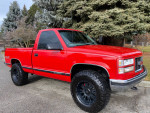 1997 GMC Sierra 1500 SL 4WD with red exterior, black wheels, and a short bed parked outdoors