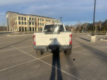 Rear view of a 2017 Ford F350 Powerstroke Lariat in a parking lot, showcasing its features and condition.